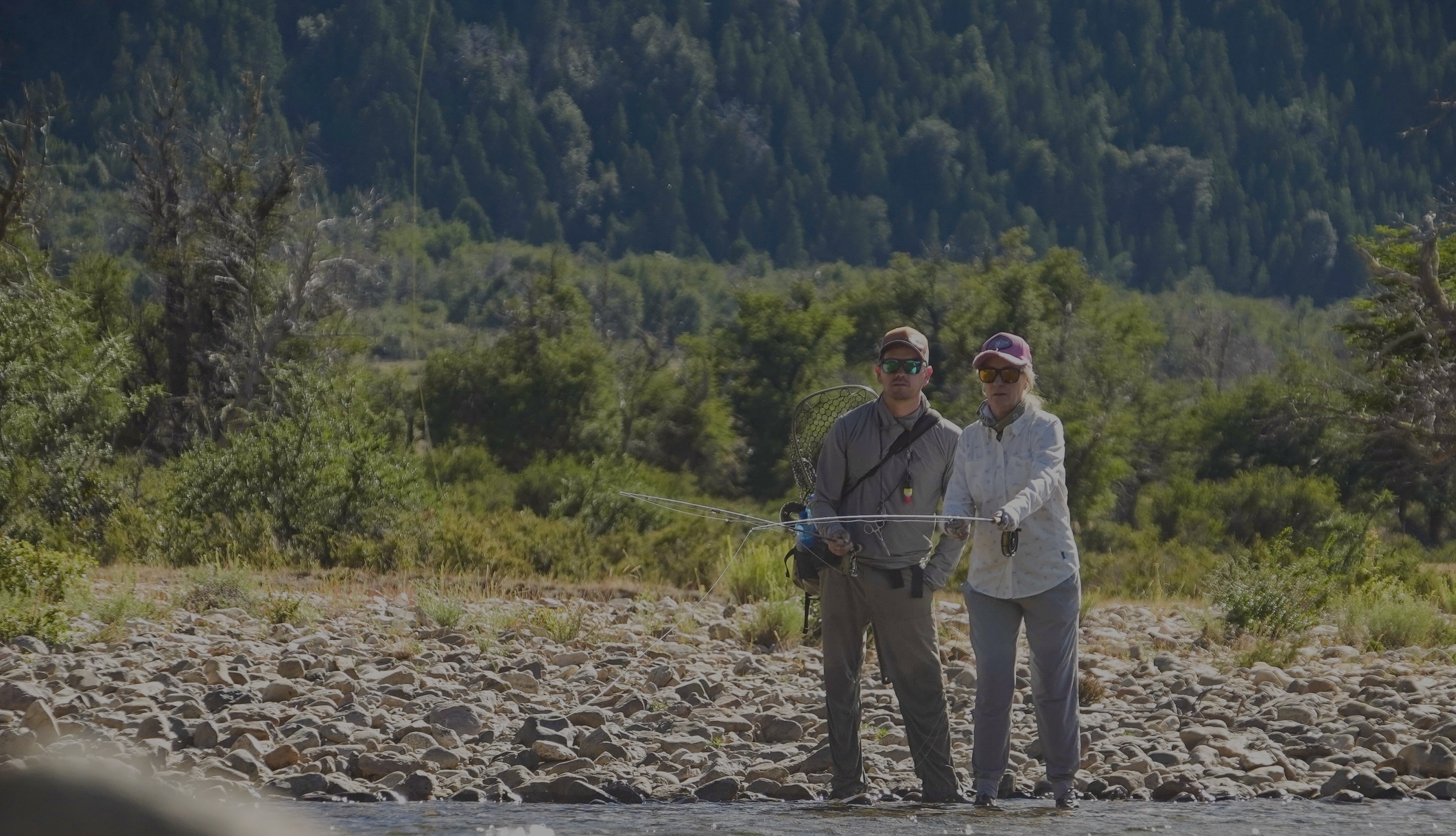 Two guides standing together on a Patagonian riverbank