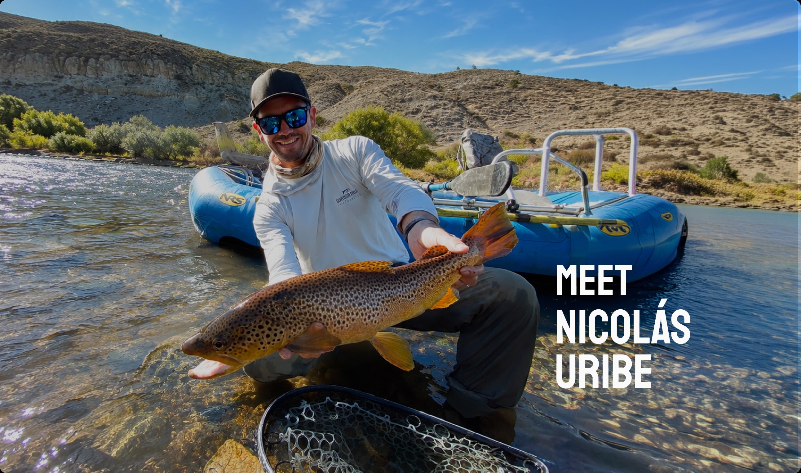 Nicol&aacute;s Uribe holding a large brown trout beside a drift boat