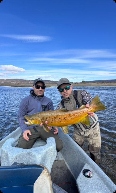 Angler in a boat holding a trout